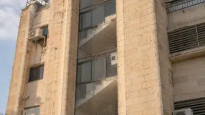 רשת נגד יונים פרושה על פתחי חדר המדרגות בחזית בניין מגורים משותף בישראל